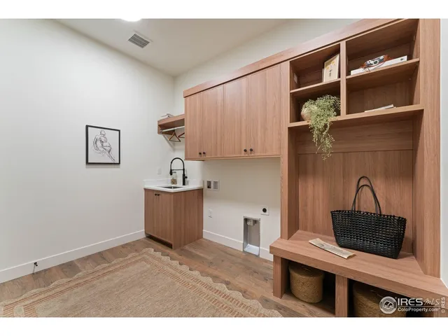 a kitchen with a refrigerator and a wooden floor