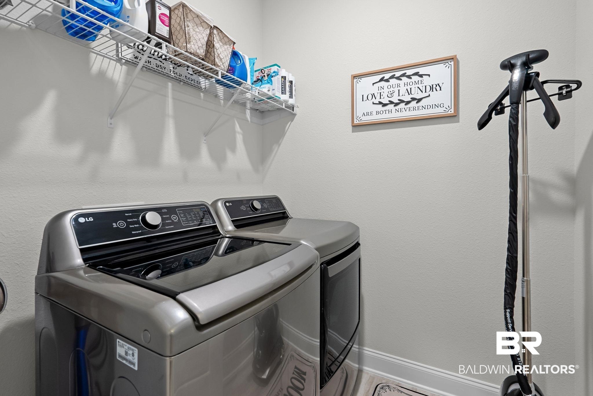 13966 Antler Hl Road Daphne, AL 36527 - Photo 26 of 44 Dedicated laundry area featuring a top-load washing machine, front-load dryer, and wall-mounted wire shelving