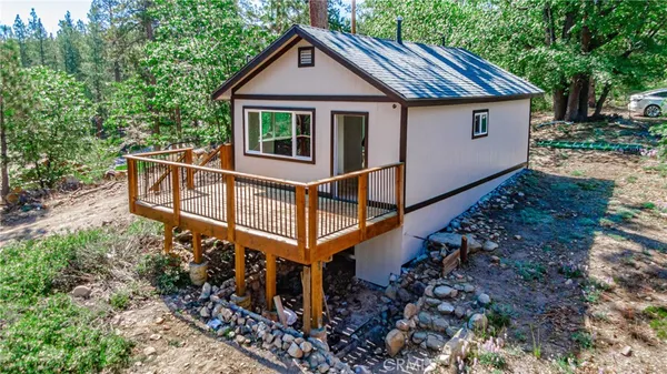 a view of house with a yard and deck area