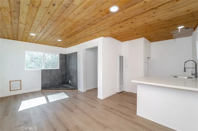 a view of a hallway with wooden floor and a sink