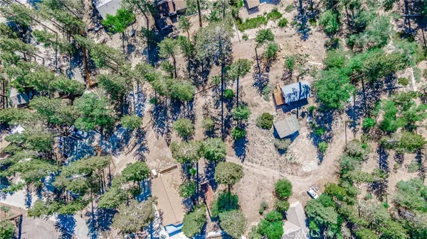 an aerial view of residential houses with outdoor space and trees all around