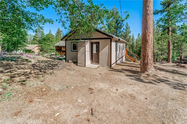 a view of a house with a yard and large tree