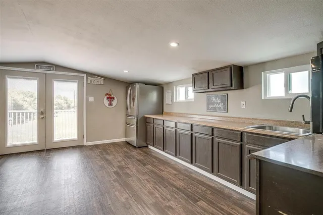 a kitchen with stainless steel appliances granite countertop a sink stove and wooden floor