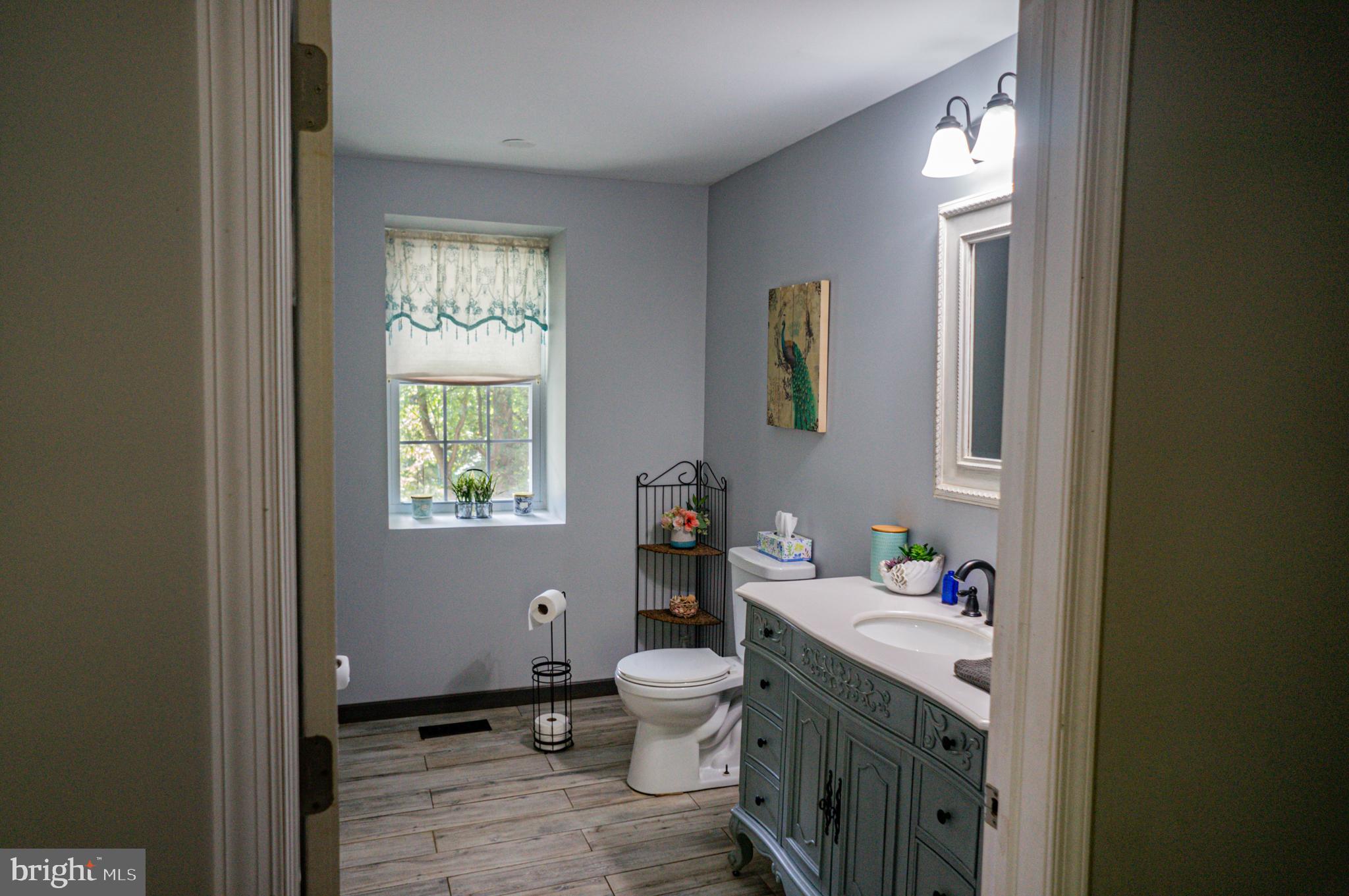 988 Kratz Road Glen Rock, PA 17327 - Photo 32 of 97 a bathroom with a granite countertop toilet a sink and a window