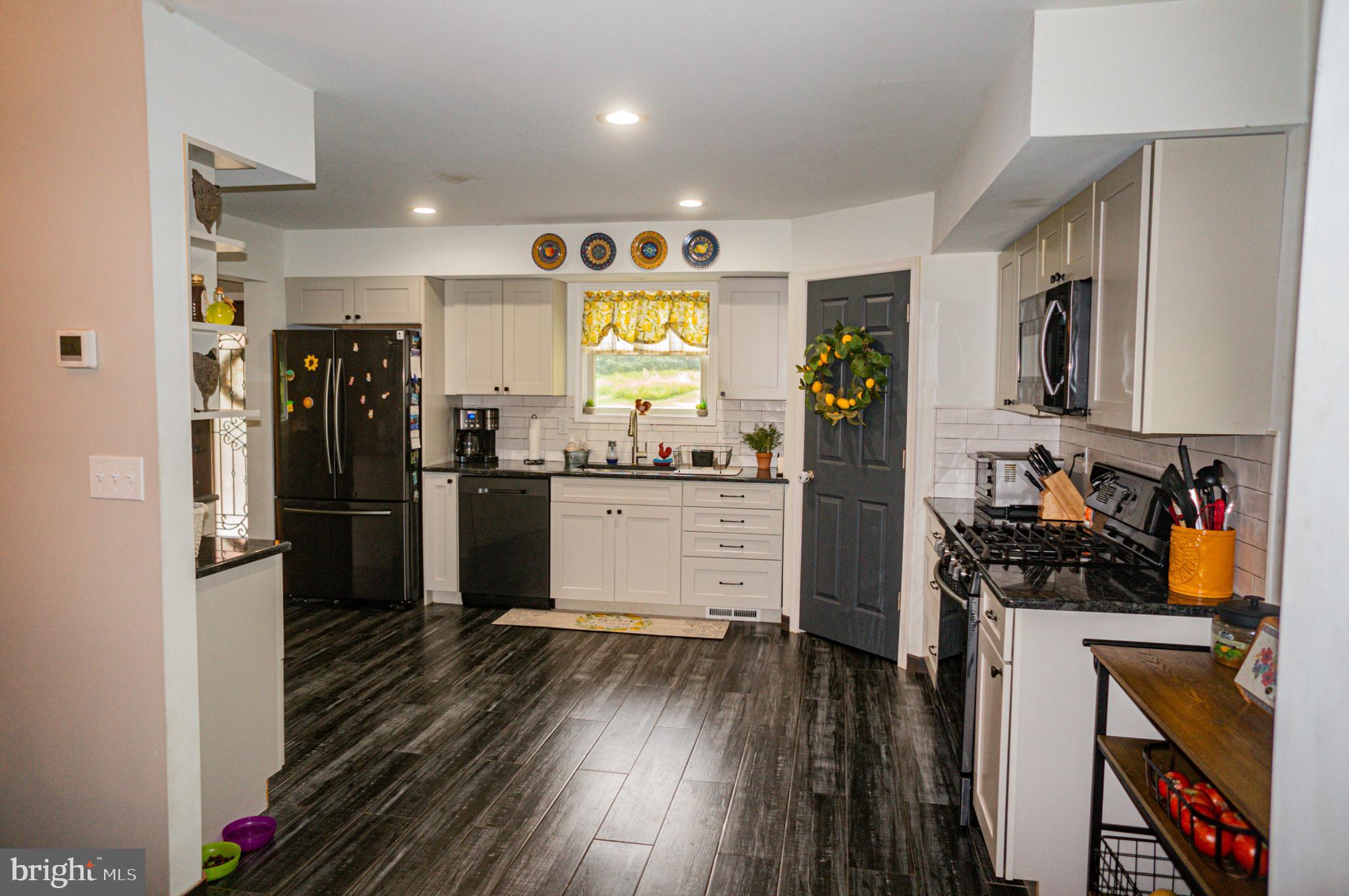 988 Kratz Road Glen Rock, PA 17327 - Photo 37 of 97 a kitchen with a refrigerator a stove top oven a counter space and wooden floor