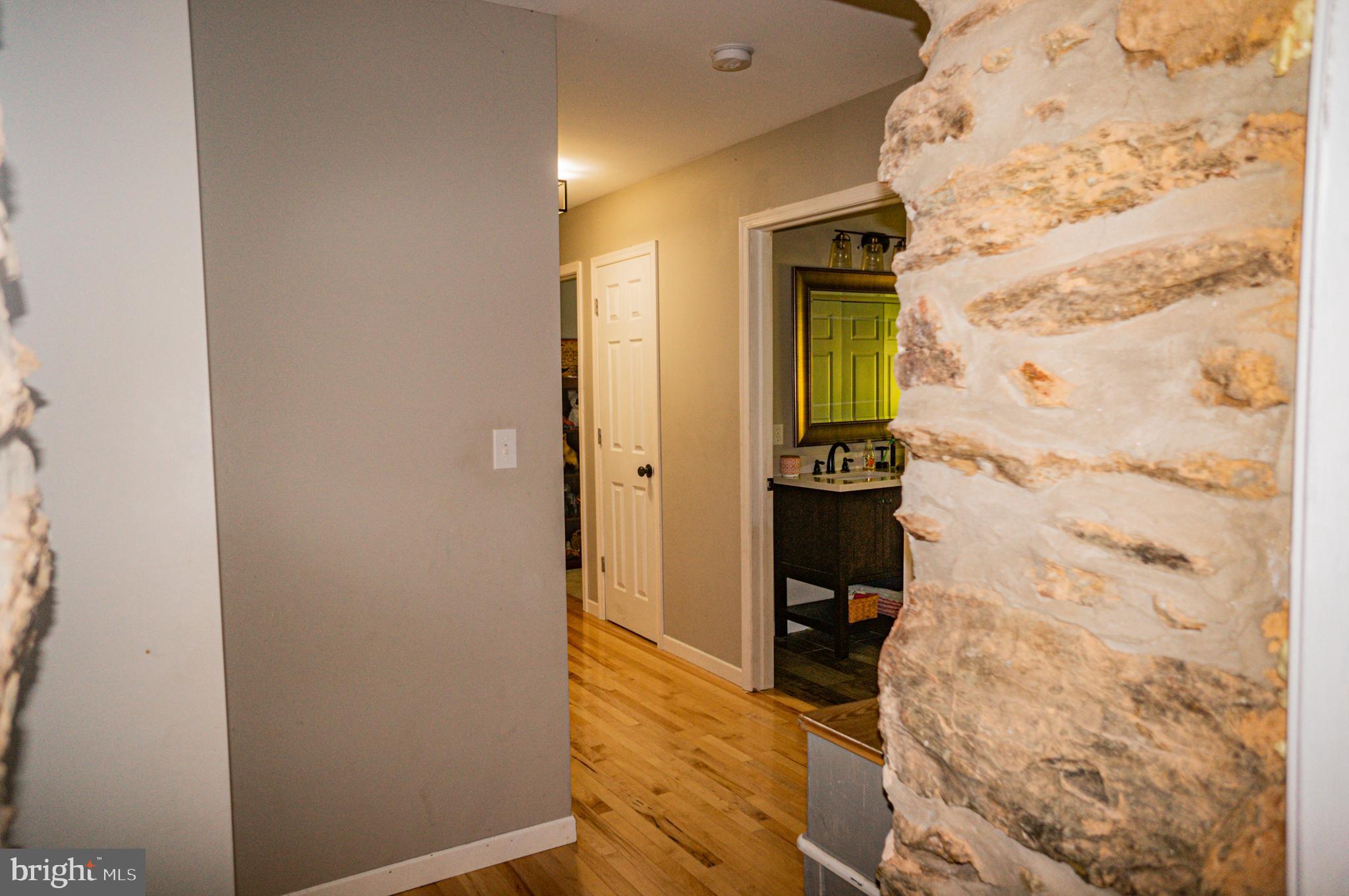 988 Kratz Road Glen Rock, PA 17327 - Photo 54 of 97 a view of a hallway with wooden floor and a bathroom