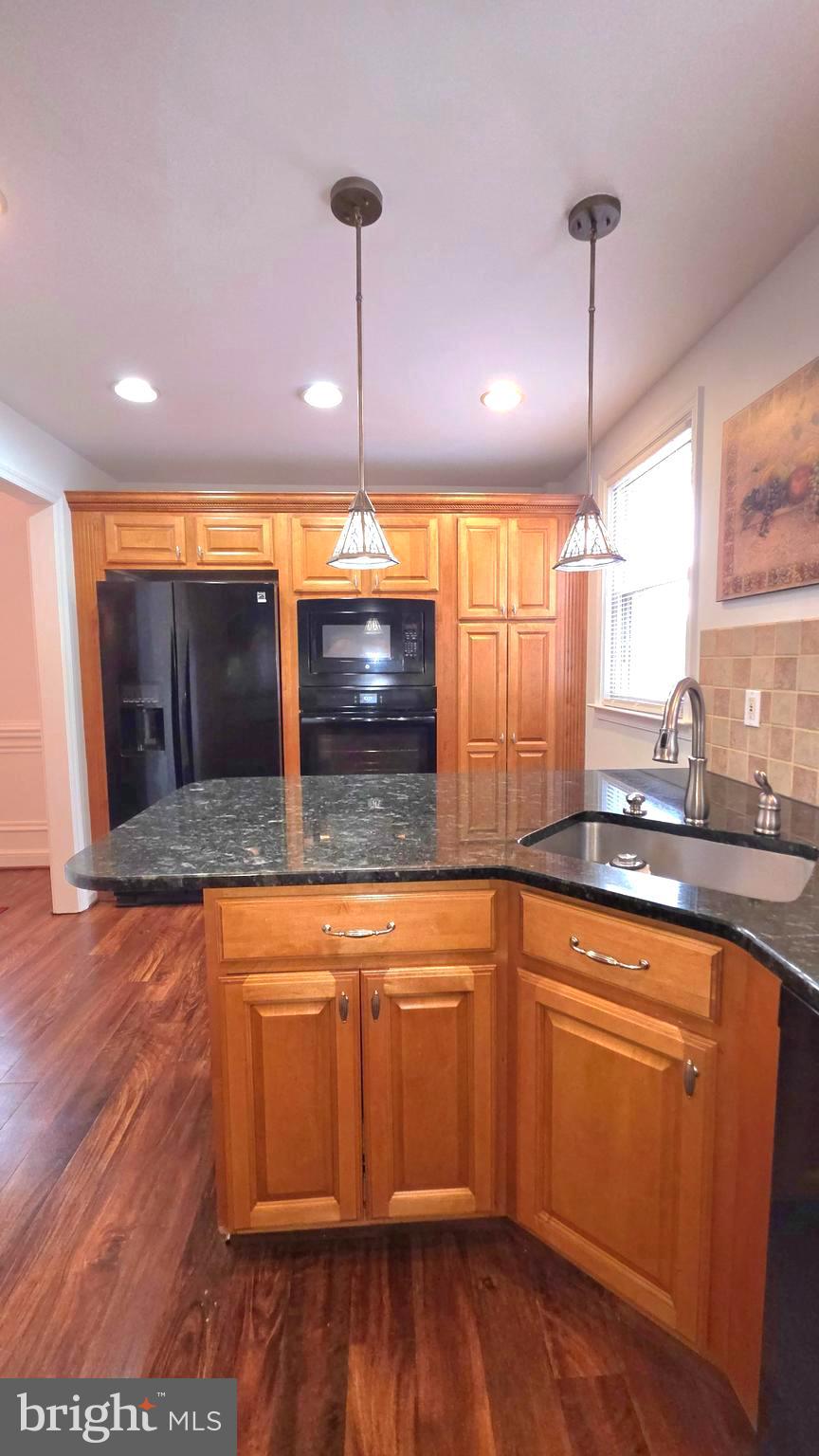 11933 Stevens Road Philadelphia, PA 19116 - Photo 8 of 17 a kitchen with stainless steel appliances granite countertop wooden floors wooden cabinets