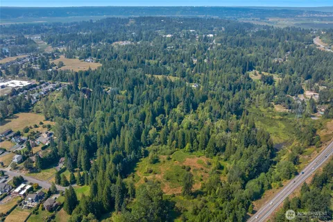 an aerial view of residential house with outdoor space and trees all around