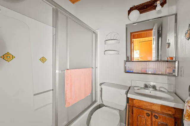 a bathroom with a granite countertop sink toilet and mirror