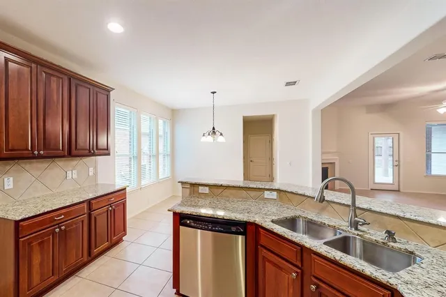 a kitchen with granite countertop a sink and cabinets