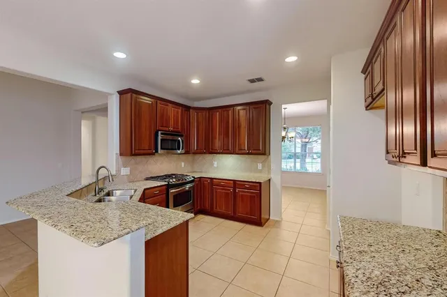 a kitchen with kitchen island granite countertop a sink stove and refrigerator