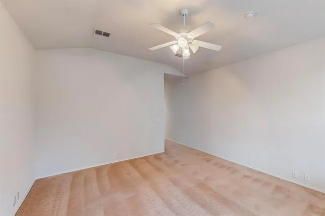 an empty room with a chandelier fan