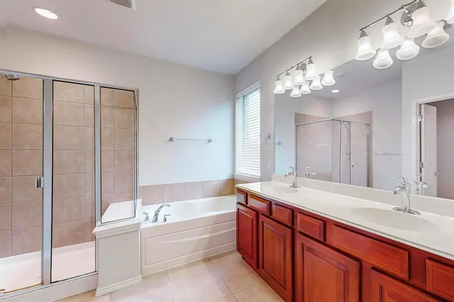 a spacious bathroom with a tub sink and mirror