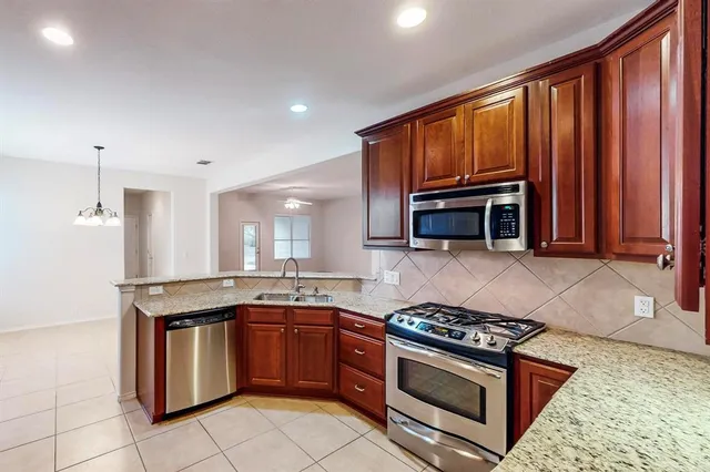 a kitchen with granite countertop stainless steel appliances and cabinets