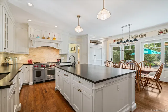 a kitchen with stainless steel appliances granite countertop a stove a refrigerator a kitchen island a sink and a stove