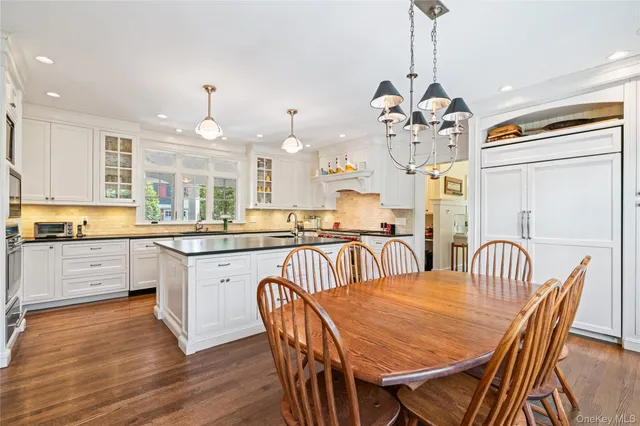 a kitchen with stainless steel appliances granite countertop a kitchen island a stove a table and chairs in it