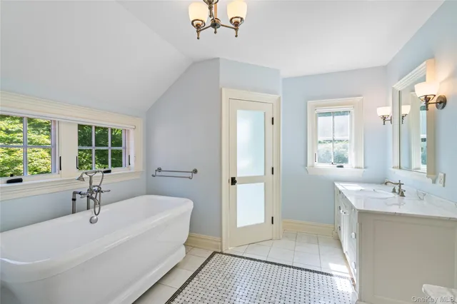 a spacious bathroom with a tub sink and mirror
