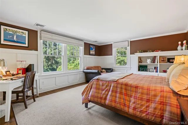 a bedroom with a bed and a large window