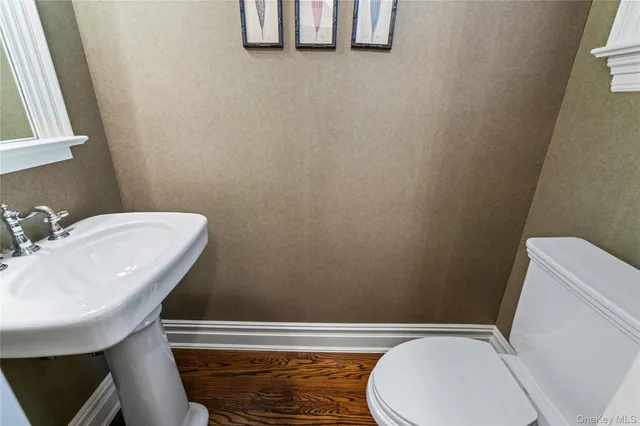 a bathroom with a toilet a sink and mirror