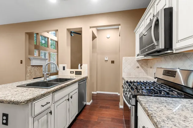 a kitchen with granite countertop a sink stove and cabinets