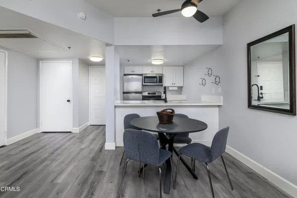 a kitchen with a dining table chairs and white cabinets