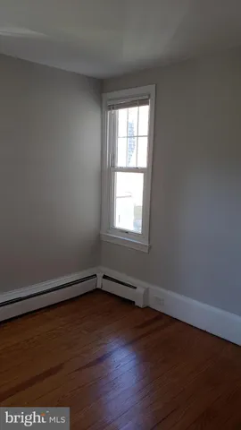 a view of a room with wooden floor and window