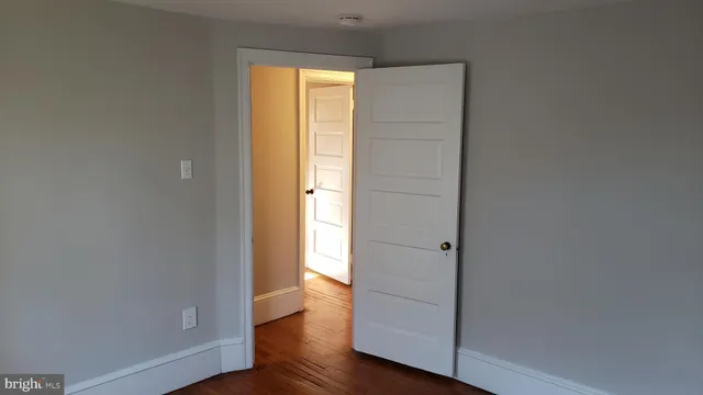 an empty room with wooden floor and closet