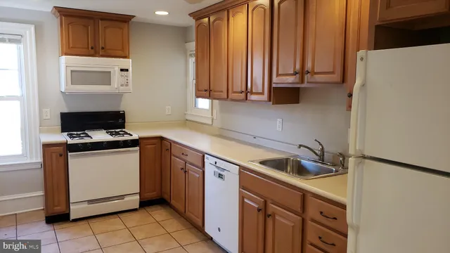 a kitchen with granite countertop a sink a stove and refrigerator
