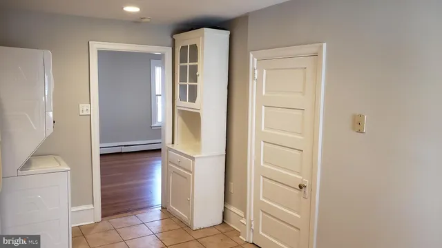a view of a hallway with wooden floor and a living room