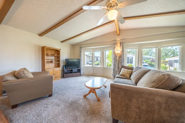 a dining room with wooden floor a chandelier a wooden table and chairs