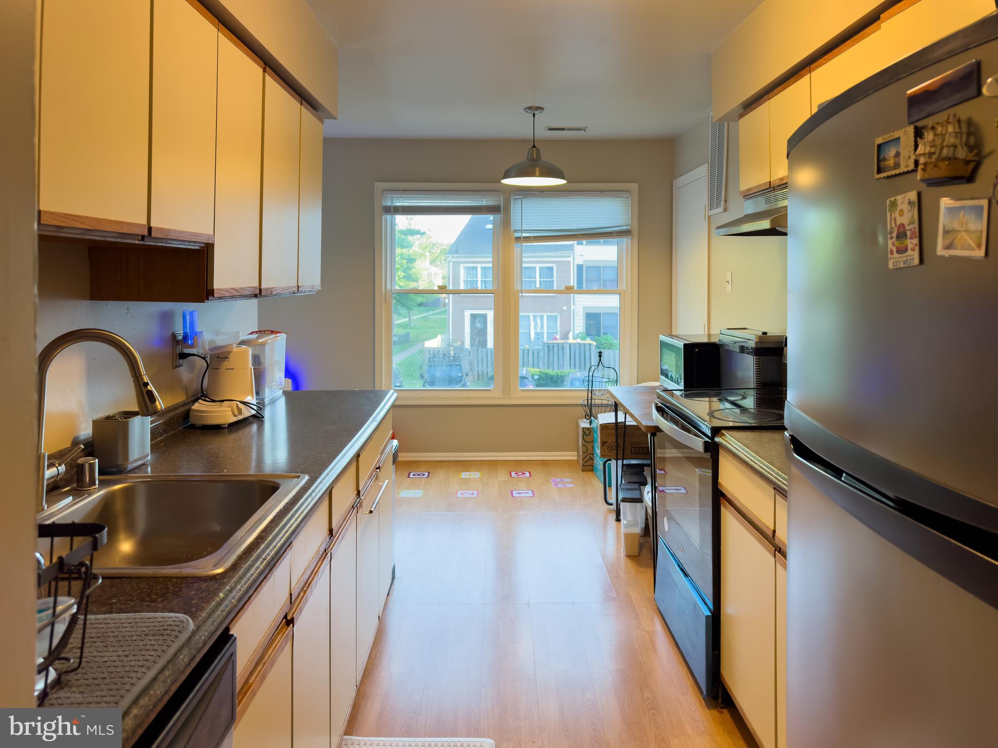 7416 Rokeby Drive Manassas, VA 20109 - Photo 11 of 17 a kitchen with kitchen island granite countertop a sink appliances cabinets and a large window