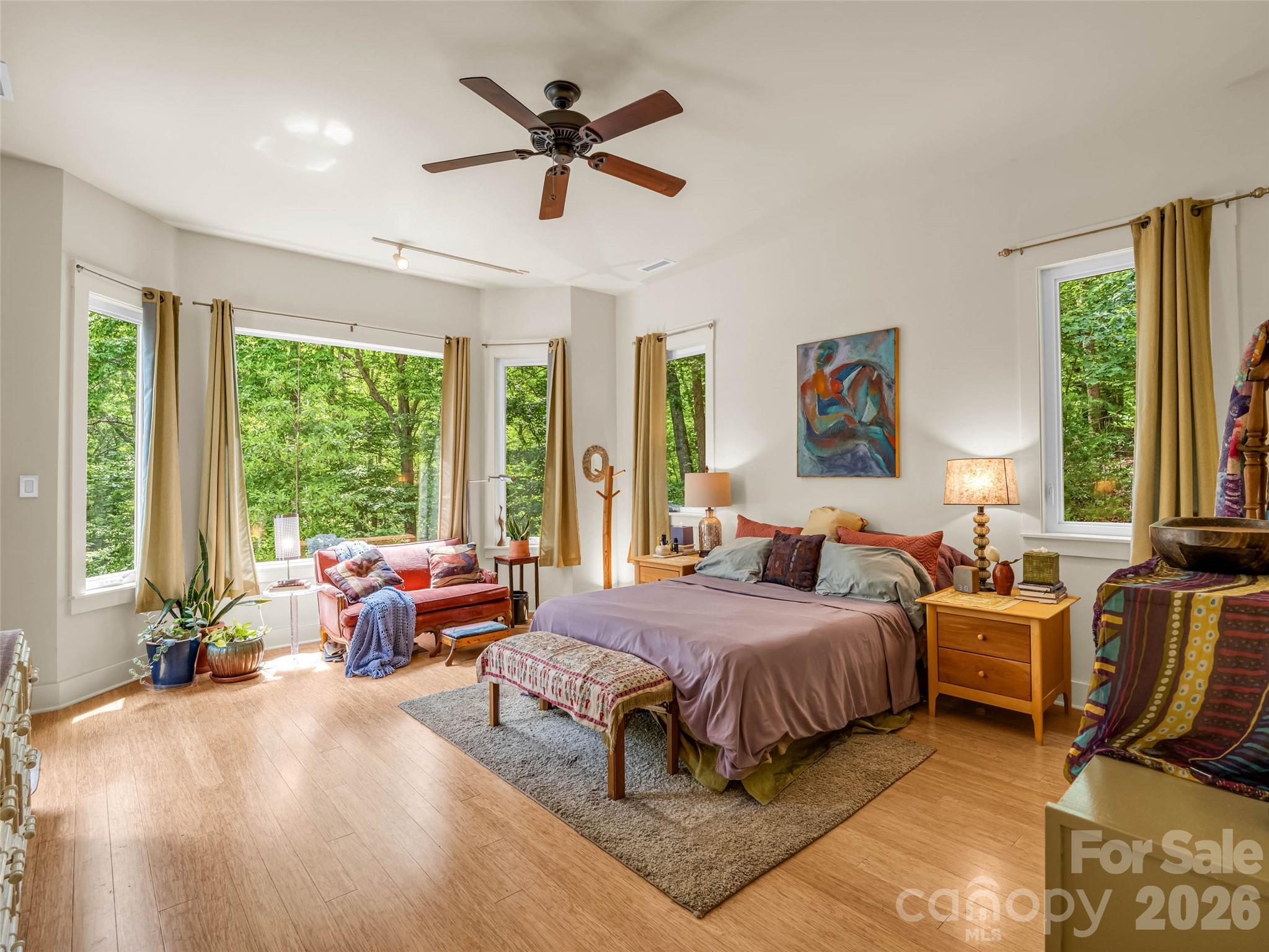 120 Glenn Court Mill Spring, NC 28756 - Photo 21 of 48 a spacious bedroom with a bed a large window and a chandelier
