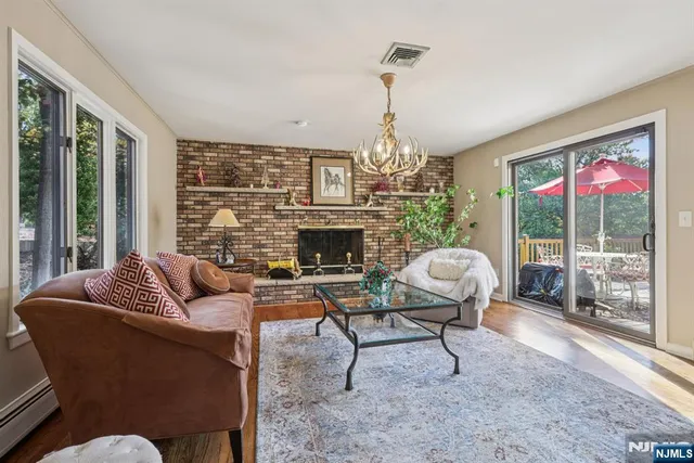 a kitchen with stainless steel appliances granite countertop a stove a refrigerator a kitchen island a sink cabinets and a dining table