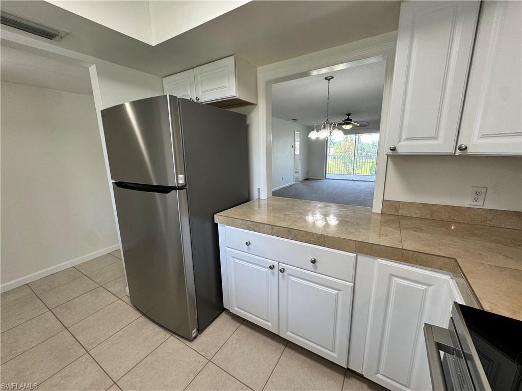5667 Rattlesnake Hamm Road North, Unit B301 Naples, FL 34113 - Photo 7 of 17 a kitchen with stainless steel appliances granite countertop a refrigerator and a sink