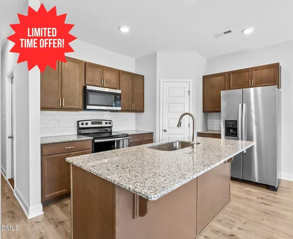 a kitchen with stainless steel appliances granite countertop a sink refrigerator and microwave