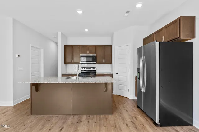 a kitchen with stainless steel appliances a refrigerator and a stove top oven
