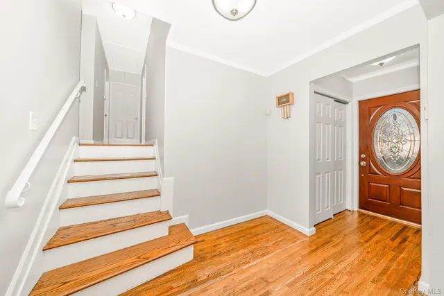 a view of a bedroom with wooden floor and white walls