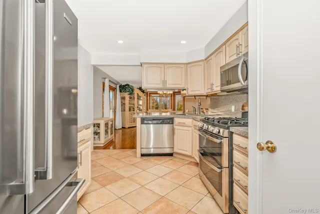 a kitchen with a stove a refrigerator and white cabinets