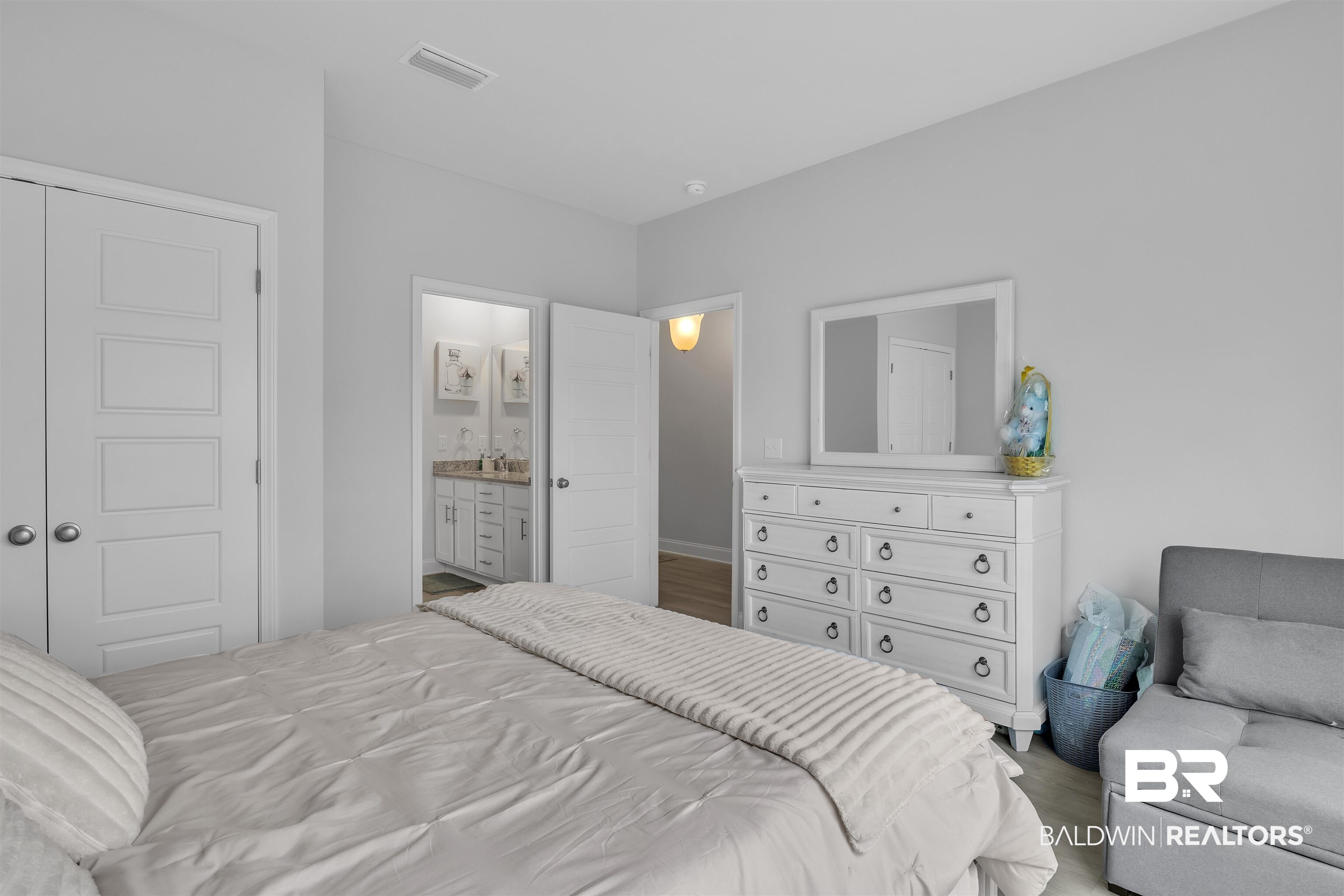 27862 Jade Court Daphne, AL 36526 - Photo 17 of 33 Bedroom featuring wood finished floors, visible vents, and connected bathroom