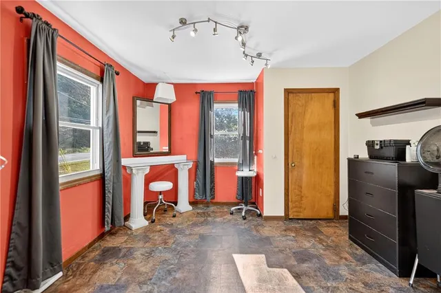 a view of a livingroom with wooden furniture and windows