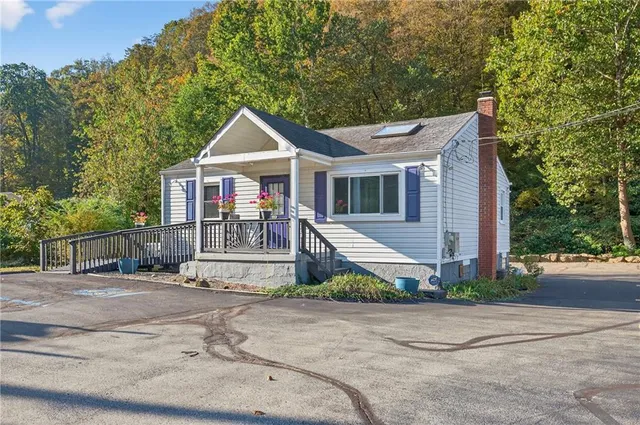 a view of a house with a yard and large tree