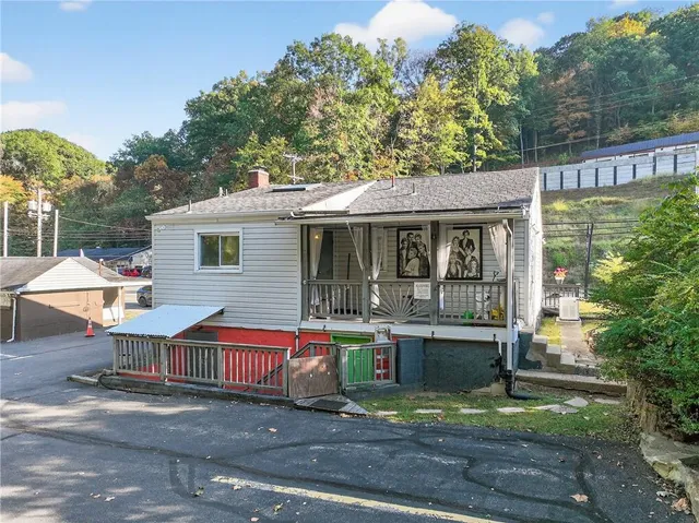 a front view of house with yard and trees in the background