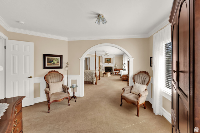 7740 Keswick Road Sandy, UT 84093 - Photo 29 of 74 Carpeted room with an arched entryway revealing an additional room with a fireplace
