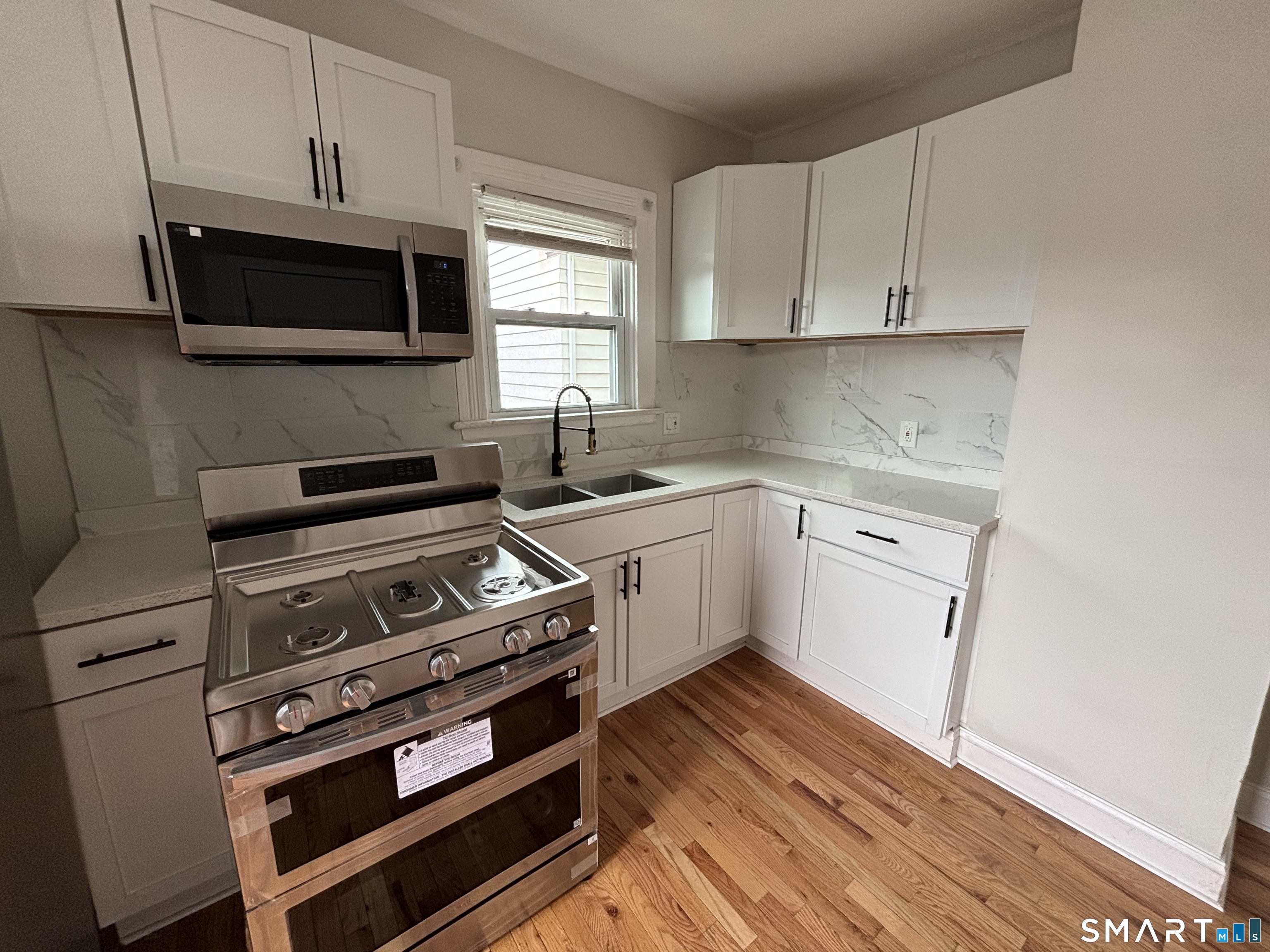 241 Lewis Street Bridgeport, CT 06605 - Photo 13 of 33 a kitchen with a stove and a microwave