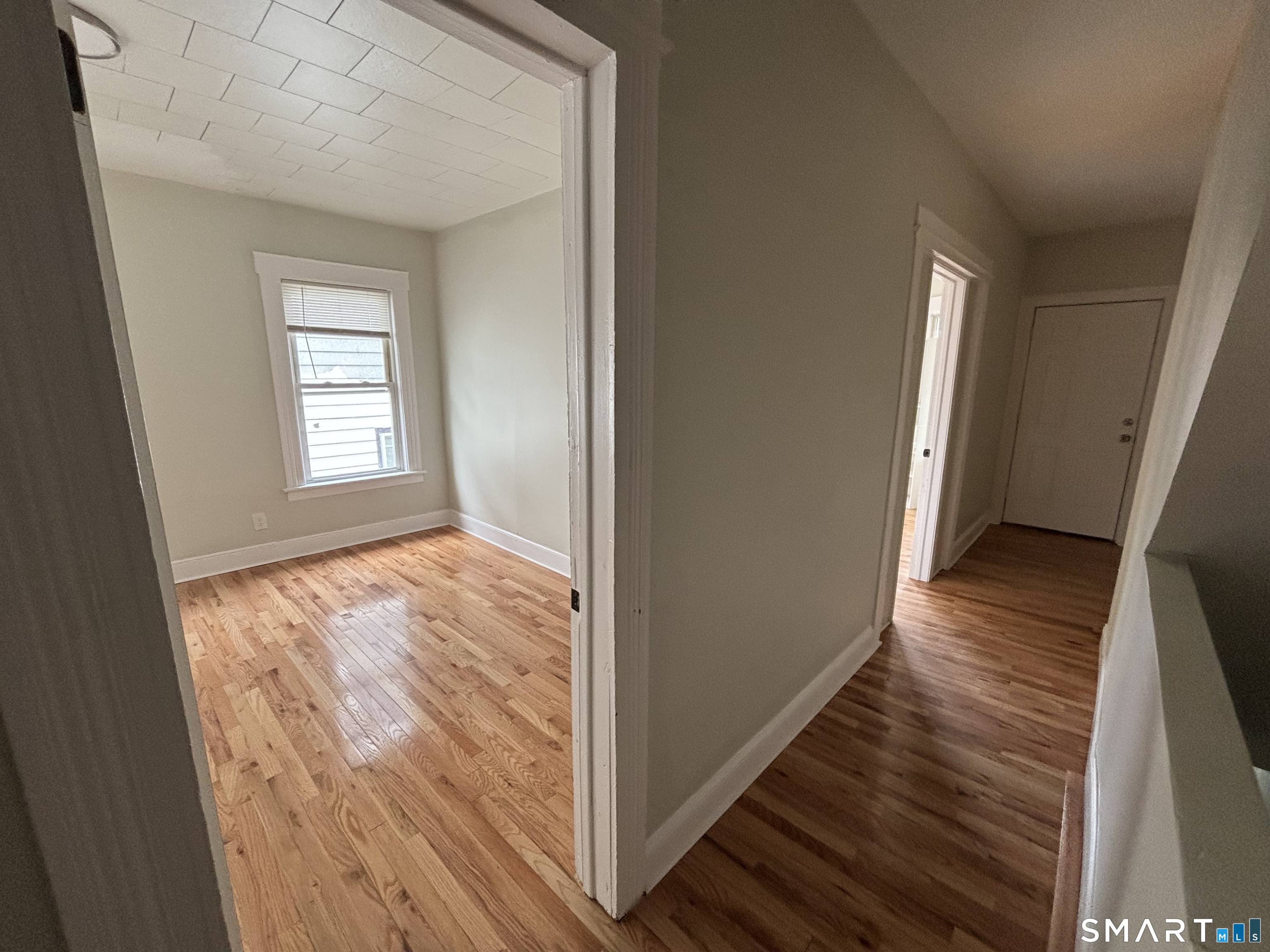 241 Lewis Street Bridgeport, CT 06605 - Photo 14 of 33 a view of an empty room with wooden floor and a window