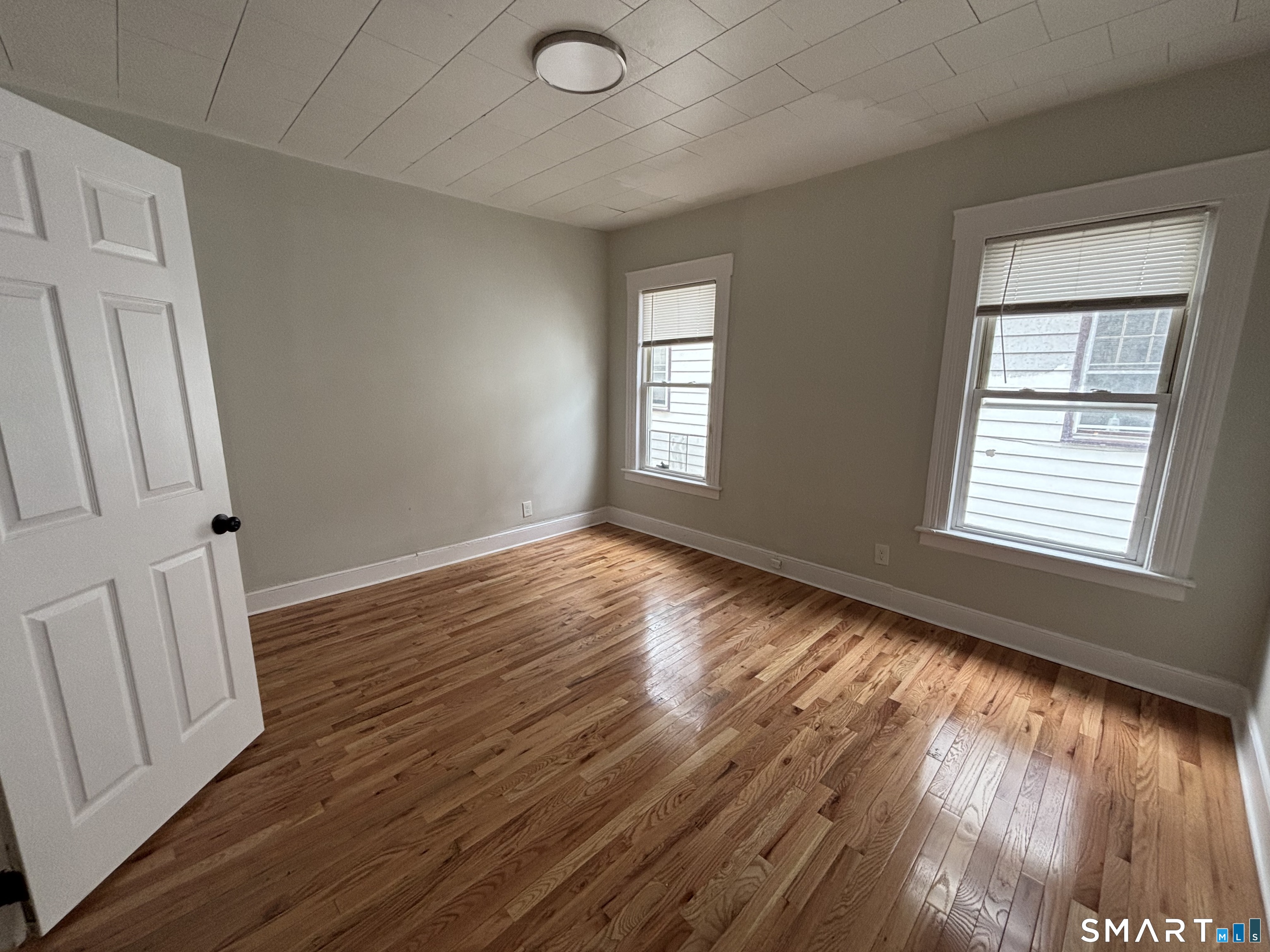 241 Lewis Street Bridgeport, CT 06605 - Photo 15 of 33 a view of an empty room with wooden floor and a window