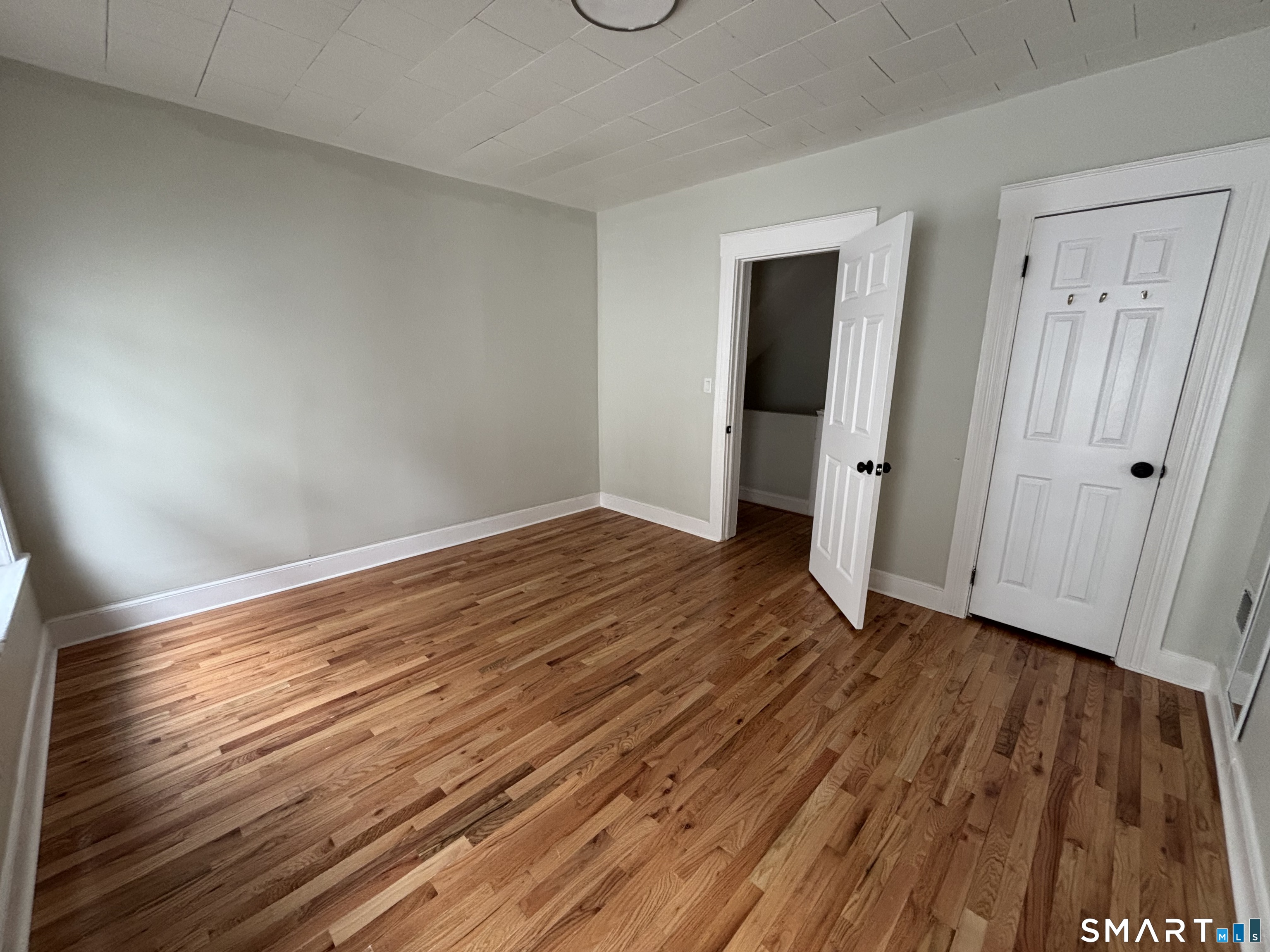 241 Lewis Street Bridgeport, CT 06605 - Photo 16 of 33 a view of a room with wooden floor and white doors