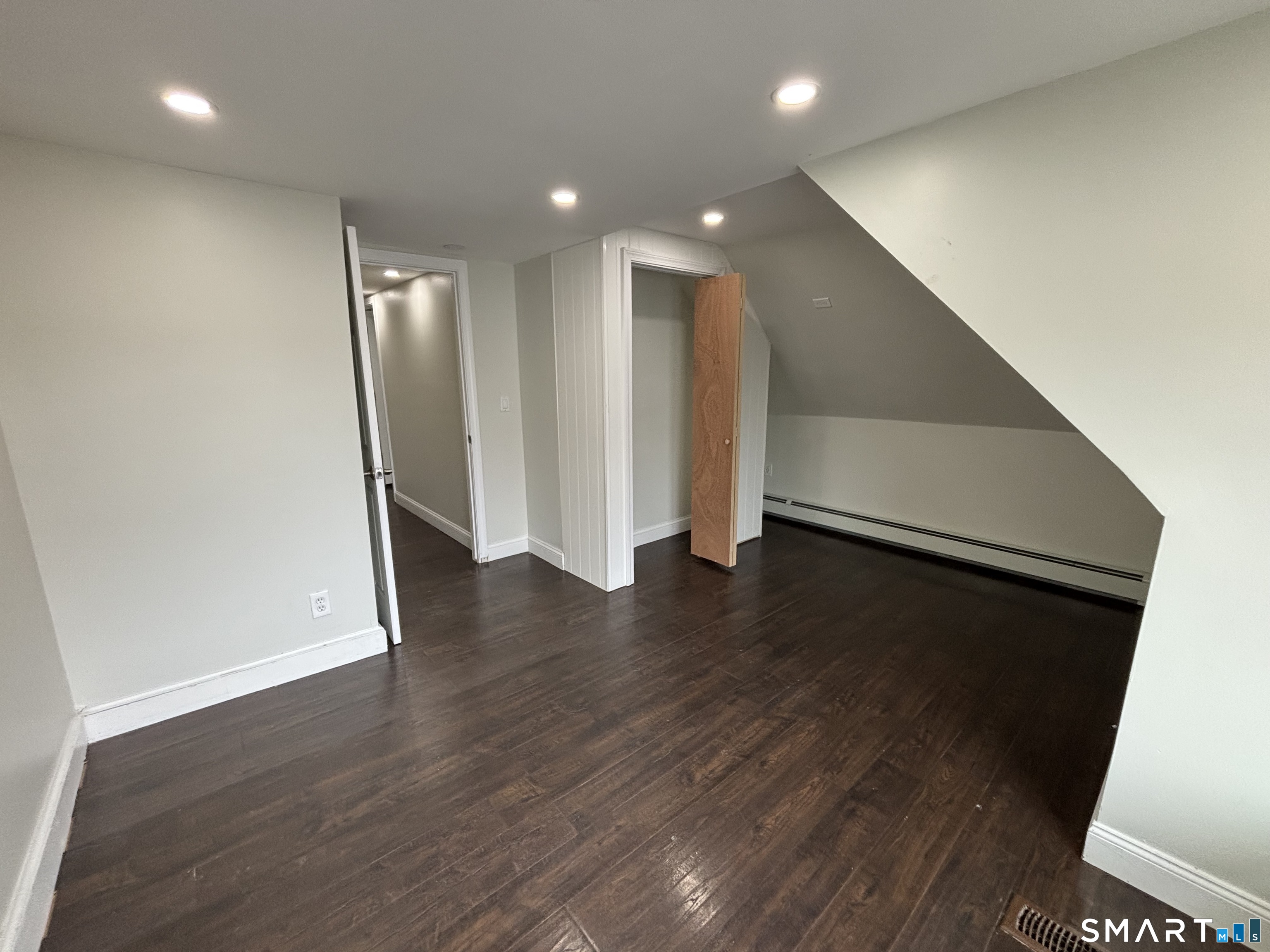 241 Lewis Street Bridgeport, CT 06605 - Photo 24 of 33 an empty room with wooden floor and staircase