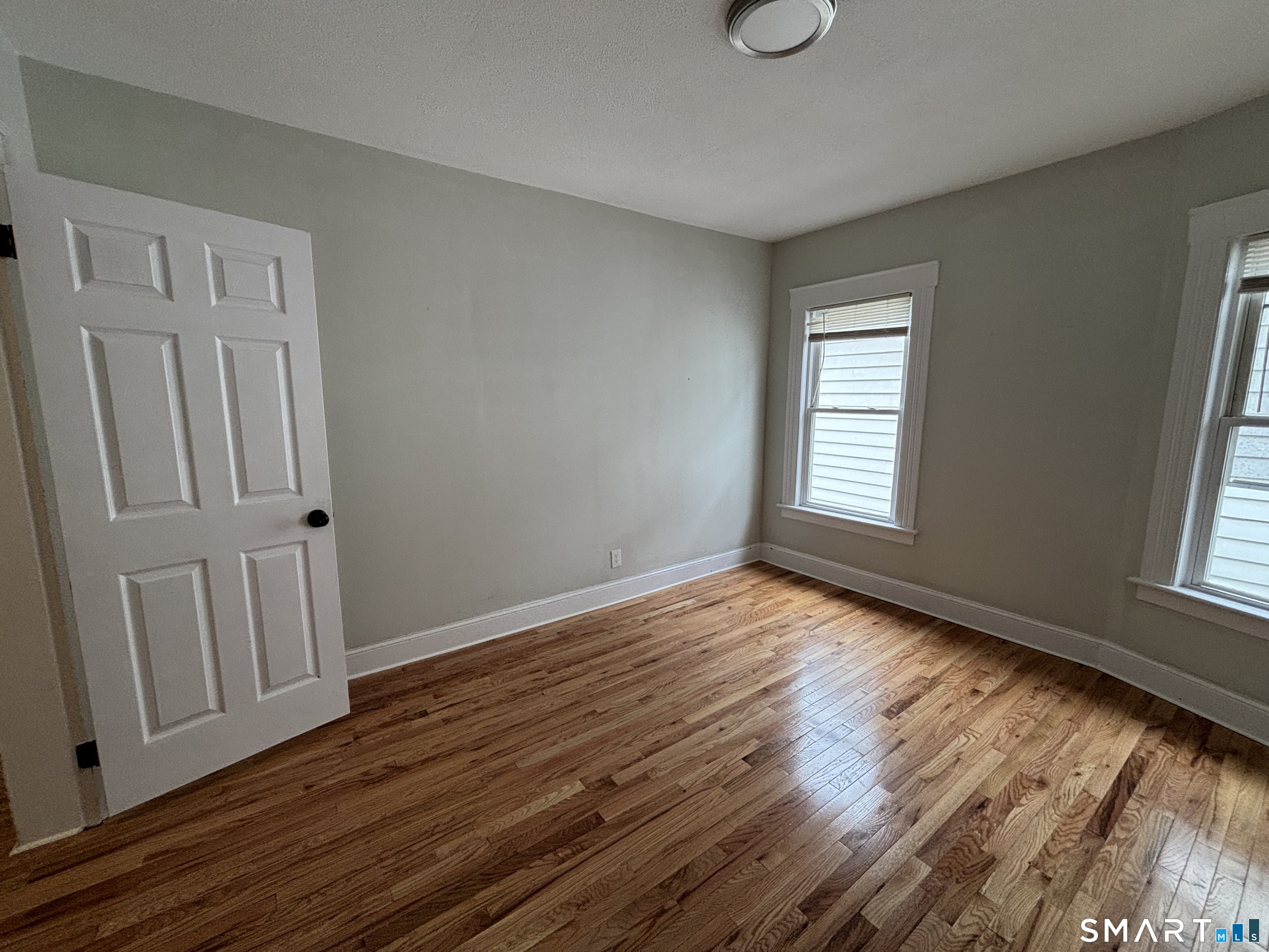 241 Lewis Street Bridgeport, CT 06605 - Photo 5 of 33 a view of an empty room with wooden floor and a window