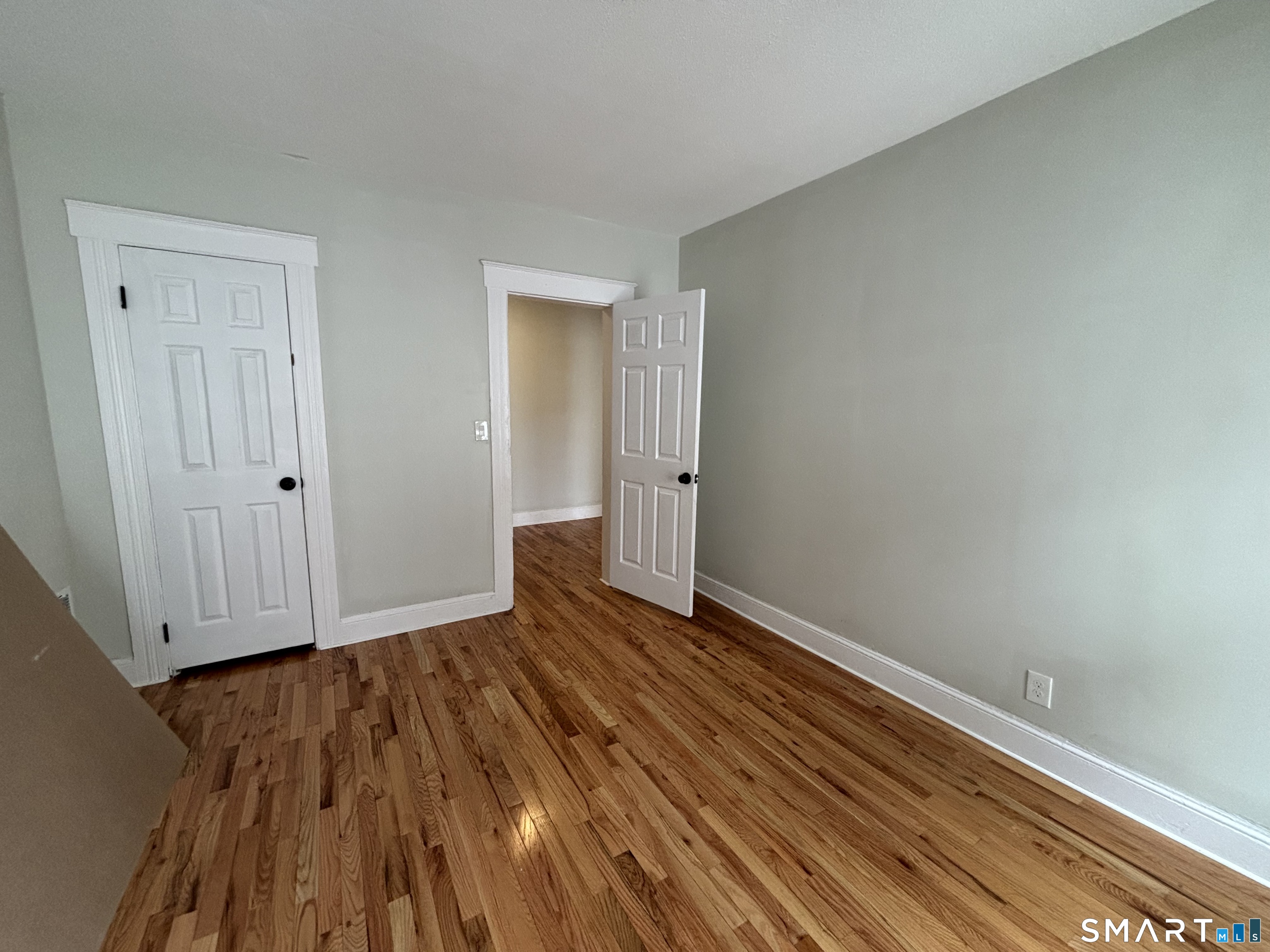 241 Lewis Street Bridgeport, CT 06605 - Photo 6 of 33 a view of an empty room with wooden floor